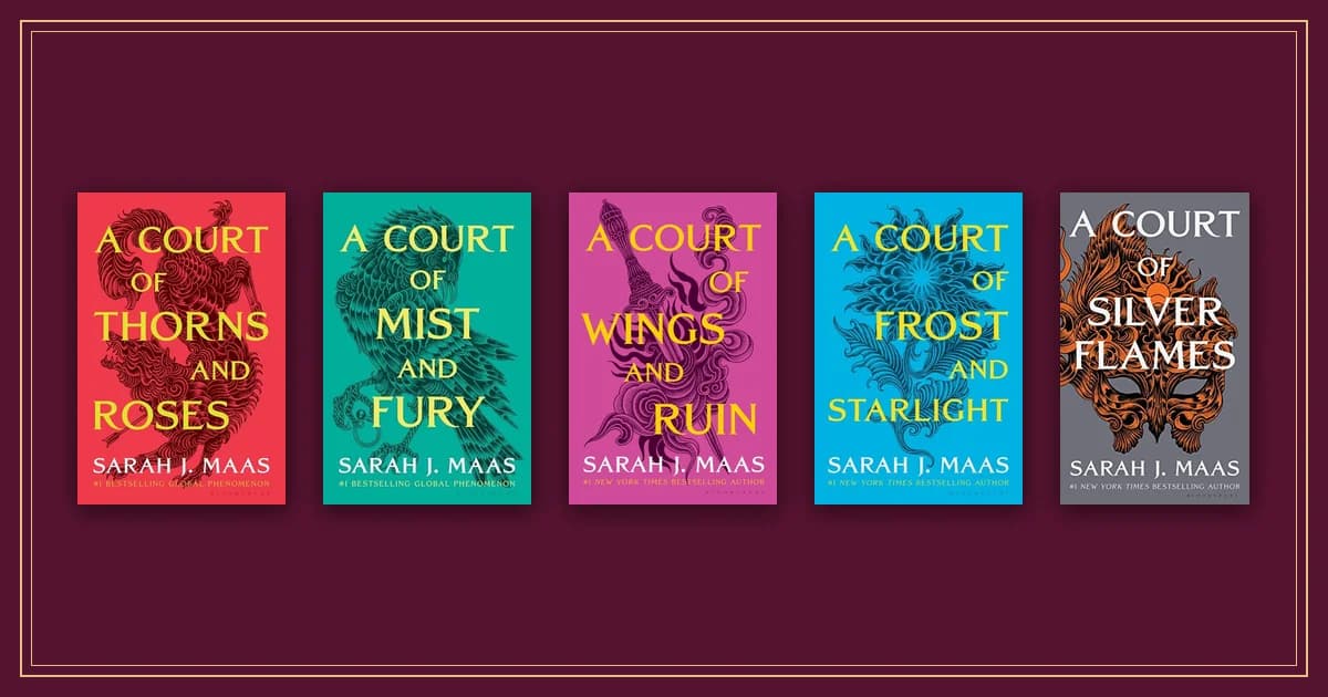 Five A Court of Thorns and Roses paperbacks in red, teal, pink, blue and grey side by side on garnet cloth